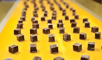 Chocoladebonbons op gele transportband