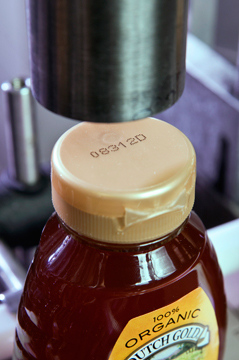 Videojet 1550 小字符喷码机在蜂蜜的塑料瓶盖上的生产日期喷印样品图