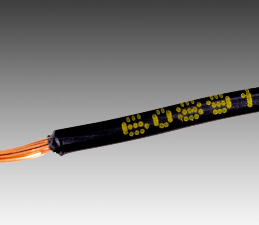 Marcação de produto a jato de tinta: código alfanumérico de linha única em tinta amarela na capa do cabo de plástico preto